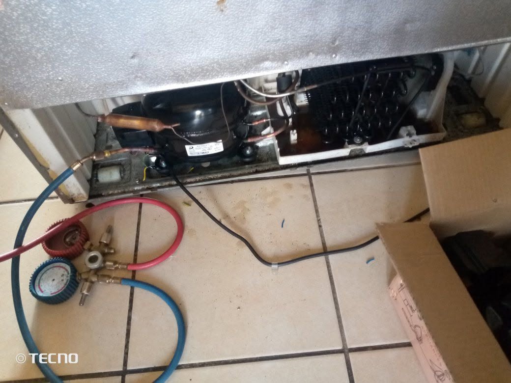 Fridge freezer being regassed with gauges connected